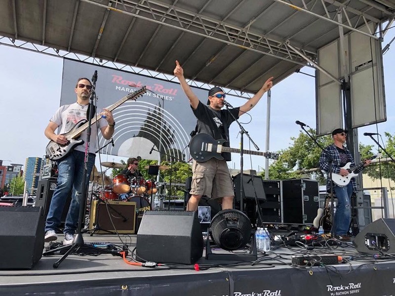 Singer with arms raised on an outdoor stage